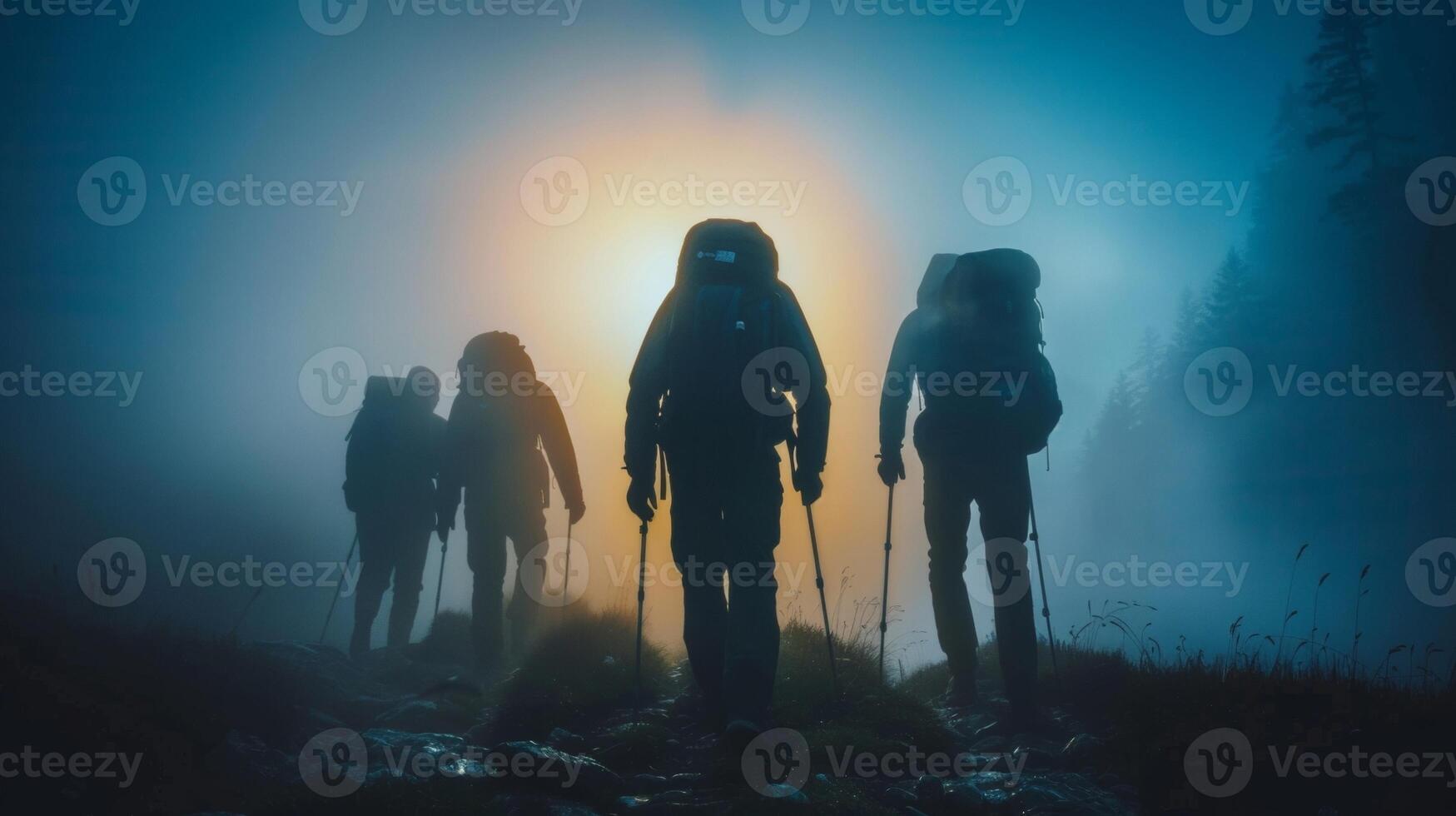 A team of adventurers identities concealed by the darkness forging ahead through the mist towards next mysterious destination. . photo