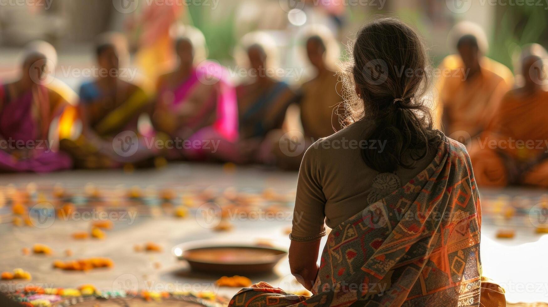 A lone figure back facing the camera sits at the edge of the group lost in own world. They appear to be contemplating . photo