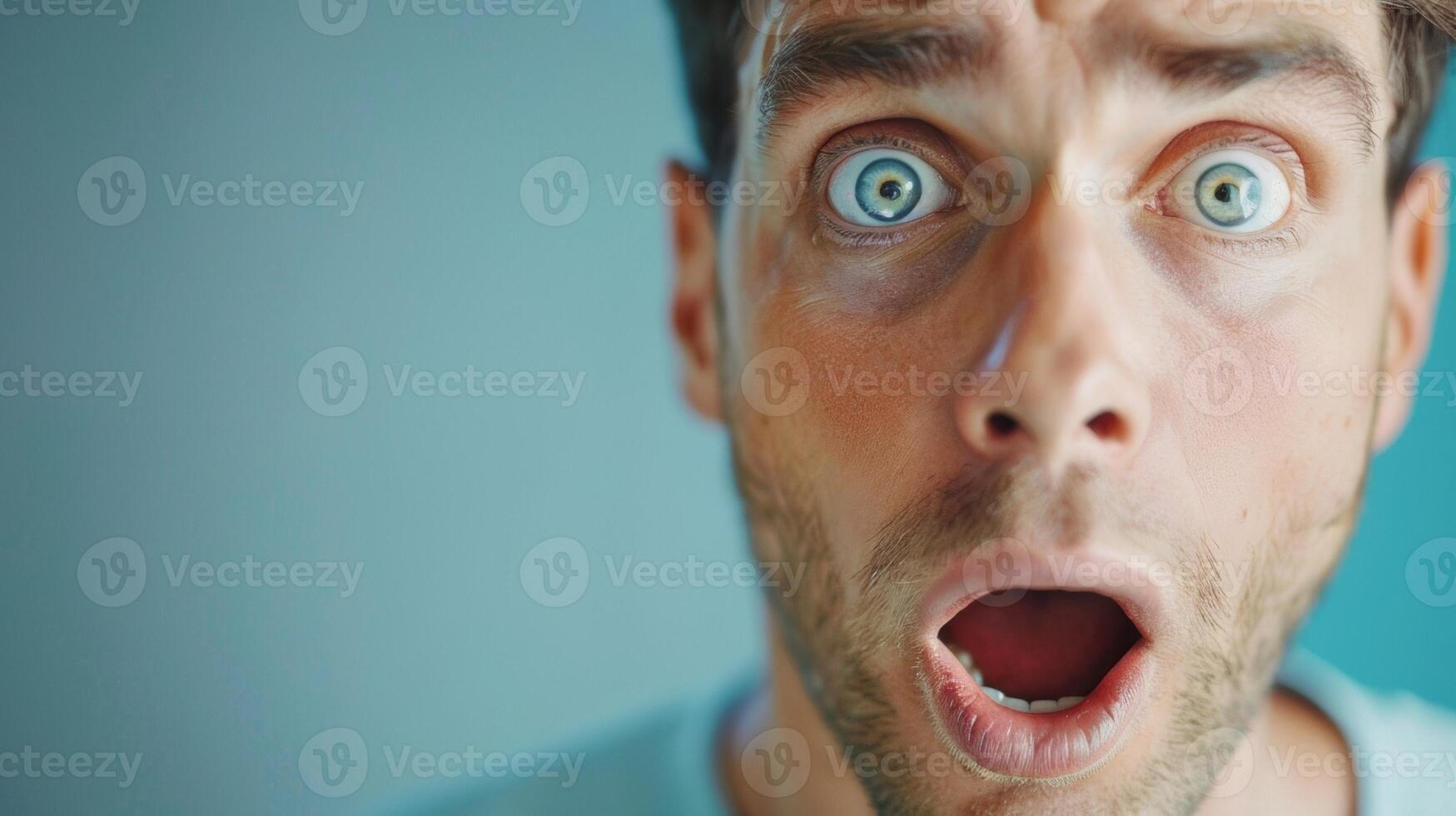 A mans eyebrows raise in surprise his mouth falling open in shock. photo