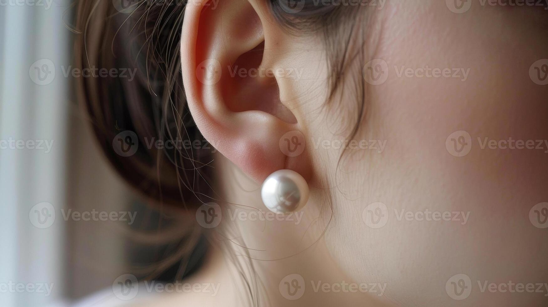 A simple pearl stud earring reflects the minimalistic style and elegant taste of its wearer. photo