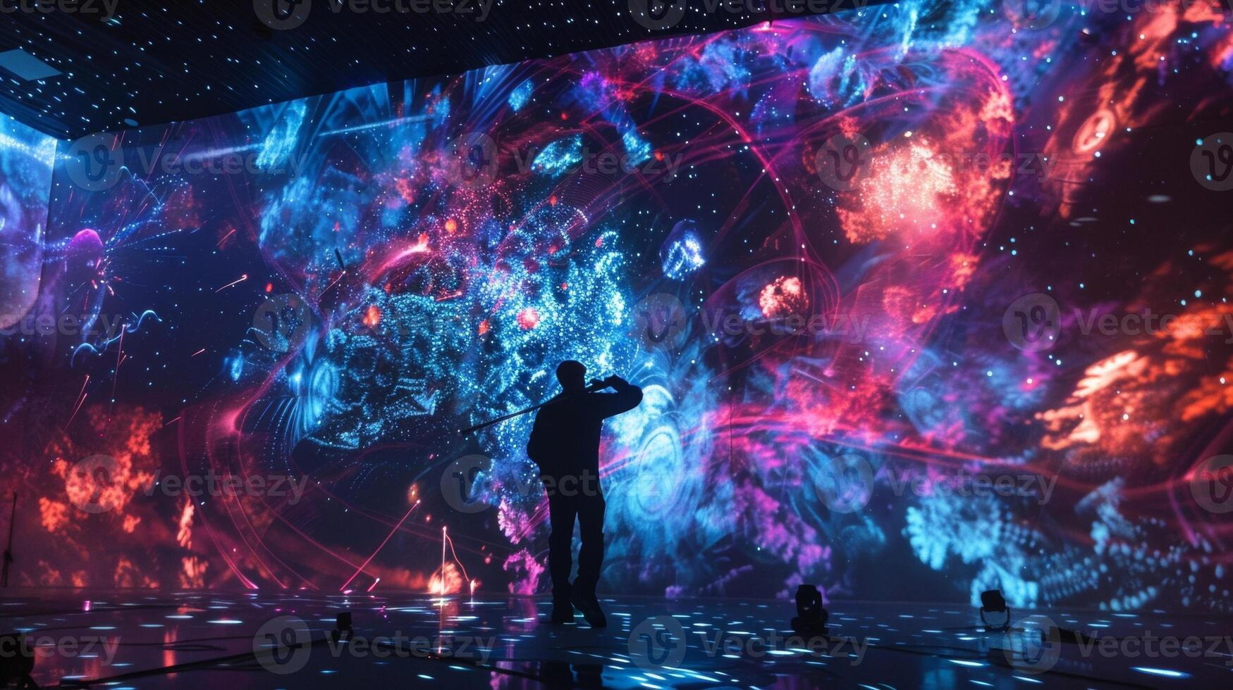 A photograph of a musician performing on a stage surrounded by screens displaying projections created using conductive ink. The ink is used to create moving images that respon photo