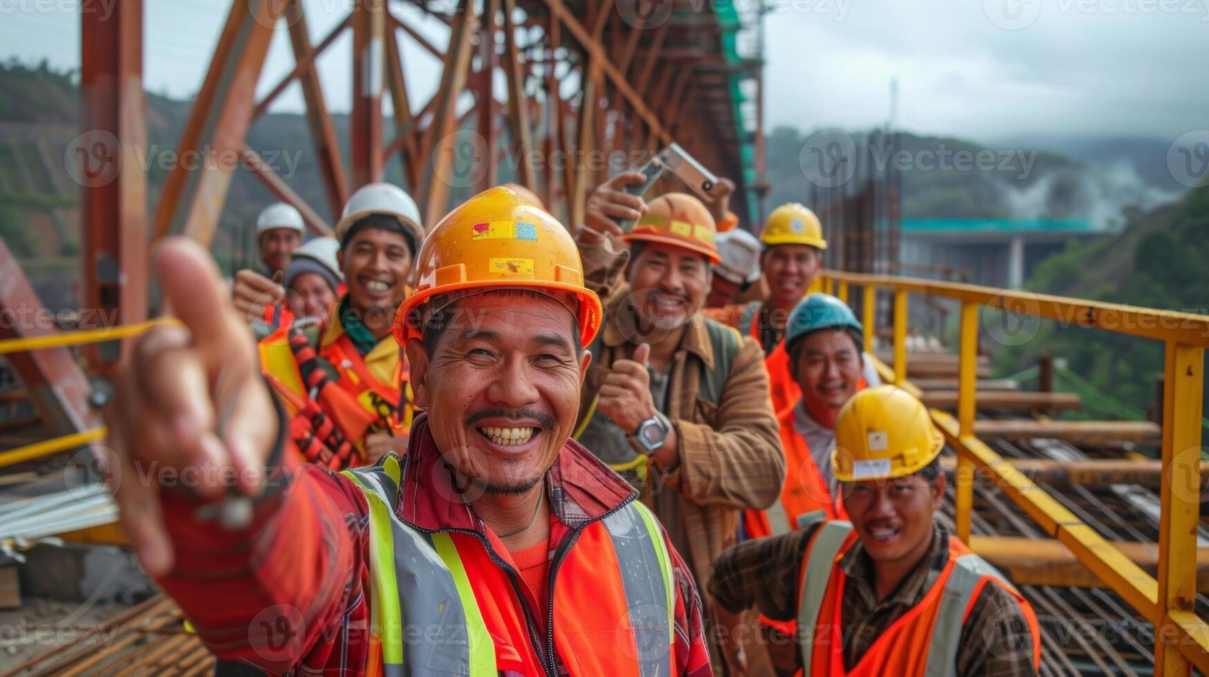 With a beaming smile a group of construction workers pose for a selfie in front of a completed section of a bridge project commemorating their teamwork and accomplishment photo