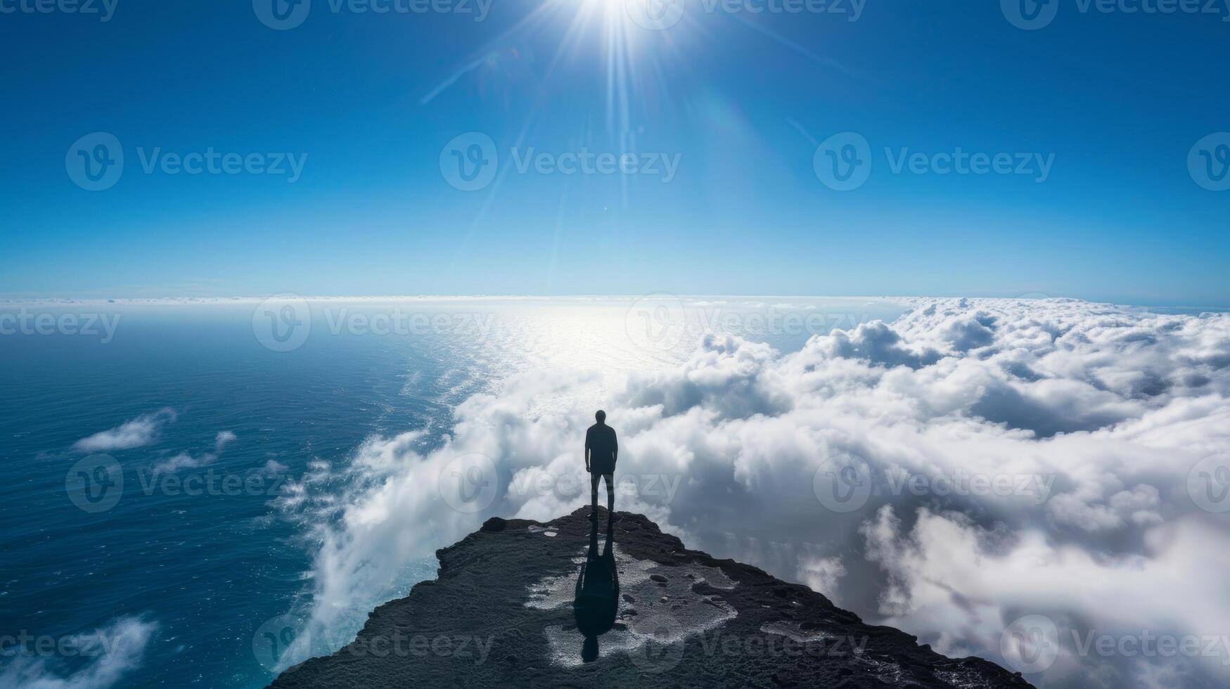 A solitary figure standing at the edge of the world their shadow taking on a life of its own in the clouds photo