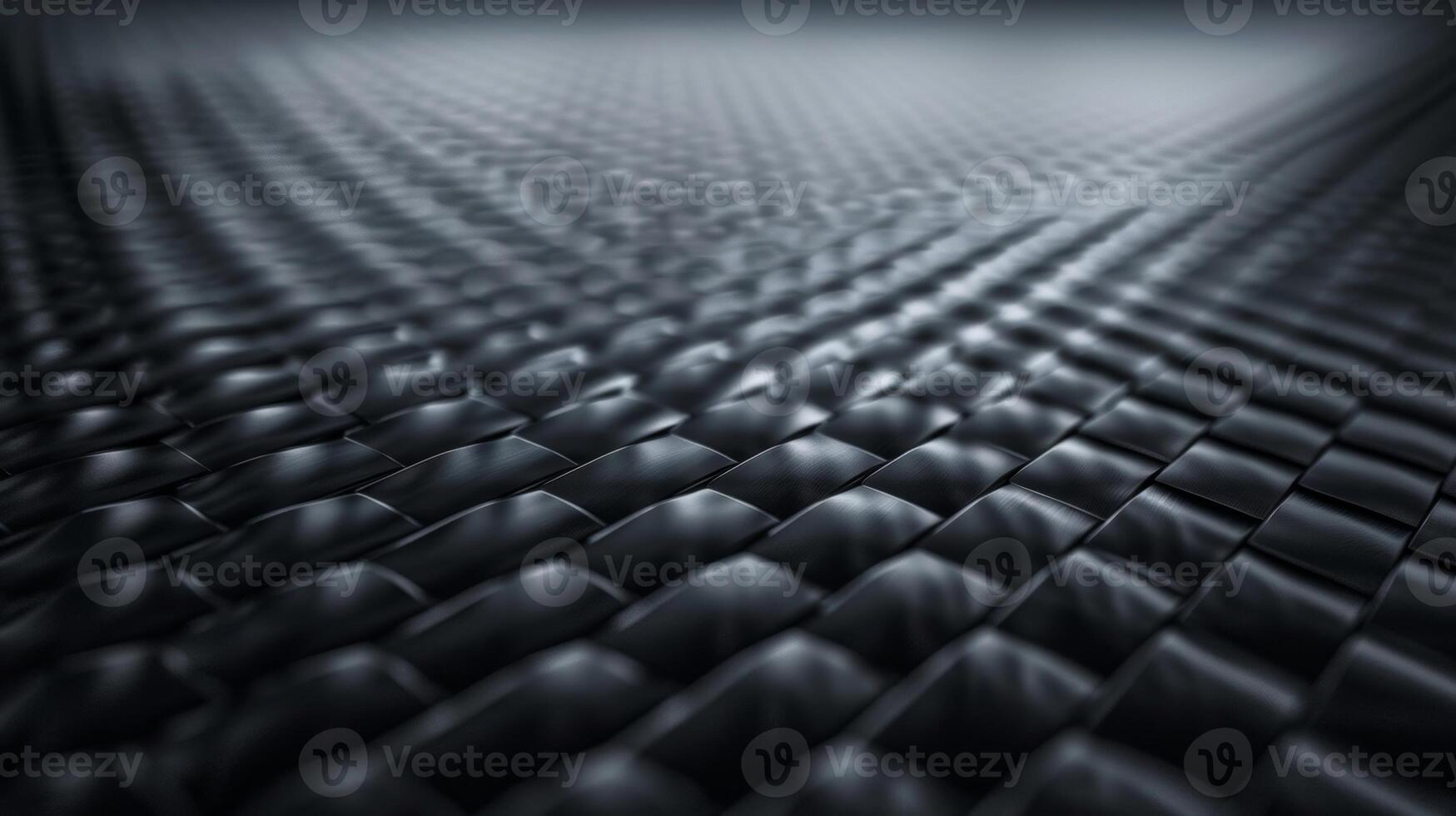 A closeup of a carbon fiber surface reveals a rich dark texture with small raised squares that give off a subtle sheen. The pattern is tight and precise exuding strength and durability photo