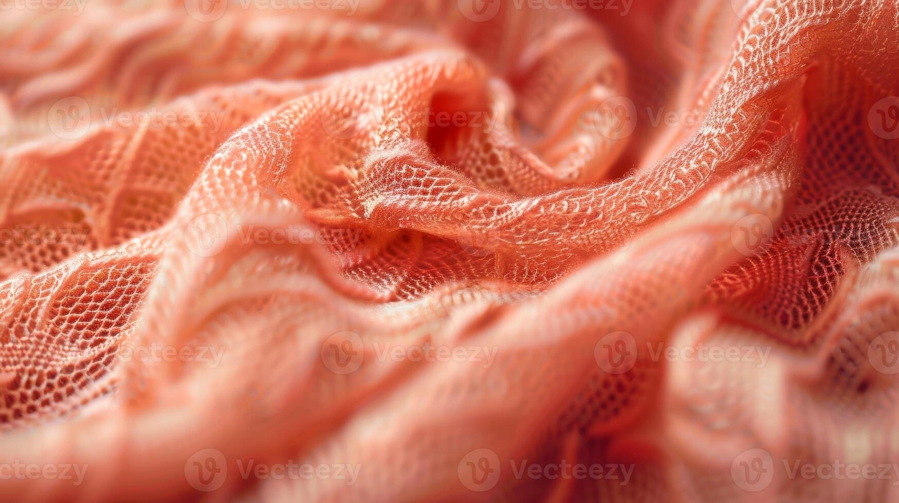 A closeup of a bright coral viscose fabric reveals an intricate weave pattern and a buttery soft texture that would be a joy to wear photo
