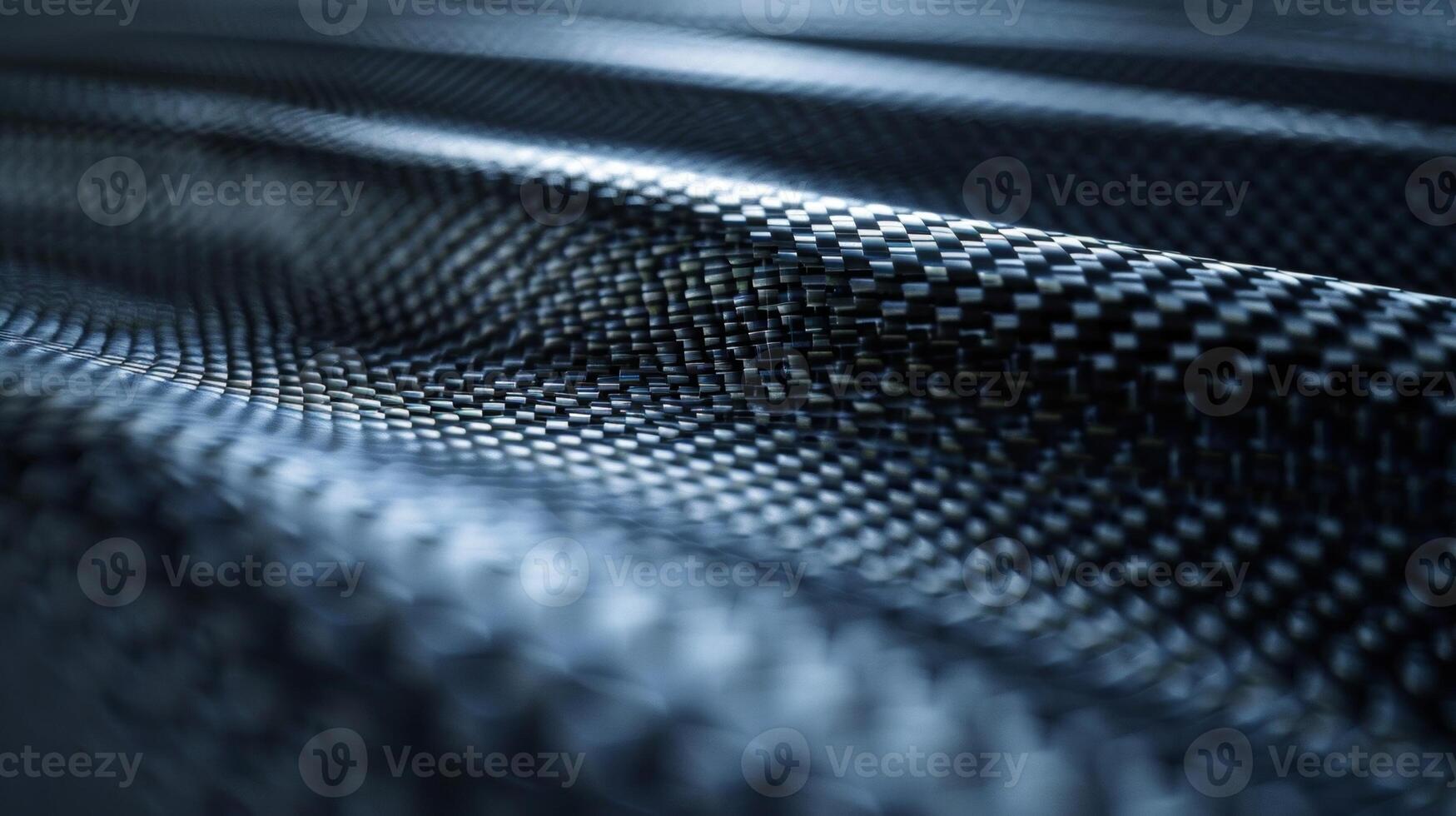A closeup of carbon fiber reveals a finely textured surface with a delicate grainy pattern. The fibers seem to intertwine and create a soft smooth texture that begs to be touched photo