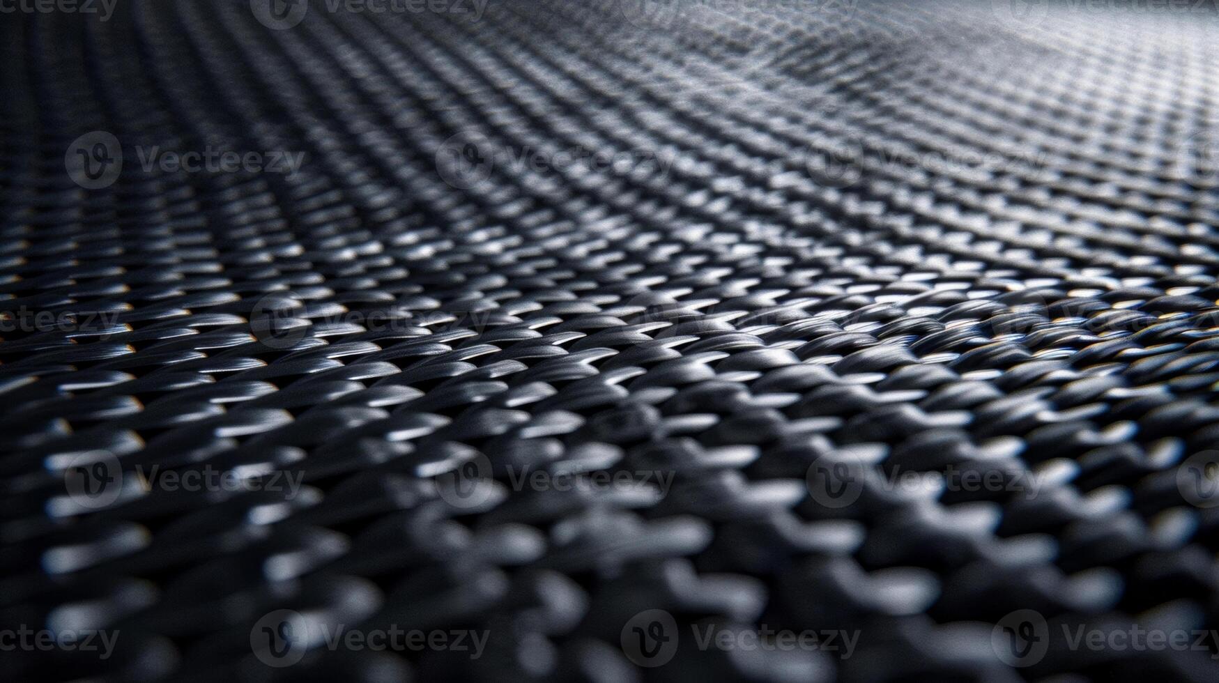 A closeup of a carbon fiber surface reveals a series of subtle overlapping layers giving off a sleek yet industrial feel. The matte finish exudes a sense of sophistication and elegance photo