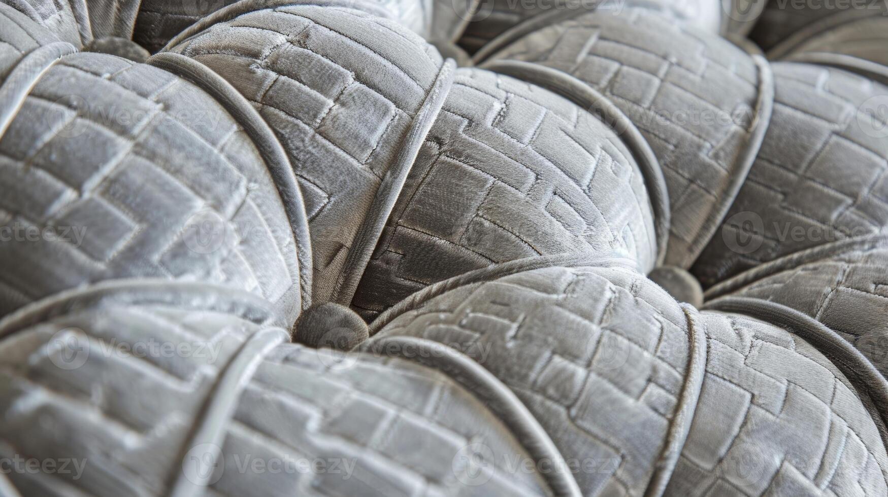 In this image the closeup of a quilted fabric headboard reveals a mix of textures. The headboard features a combination of soft plush velvet fabric and a more structured quilted patter photo