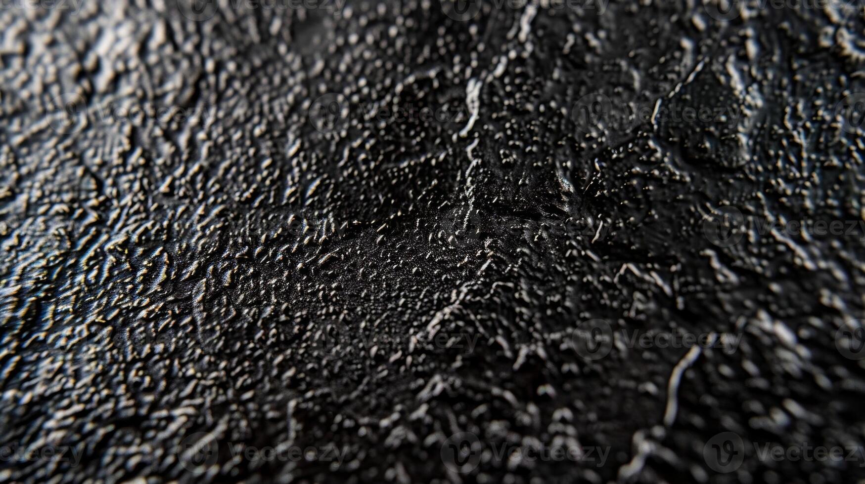 A macro shot of matte black metal displaying a bumpy speckled texture with a matte nonreflective quality photo