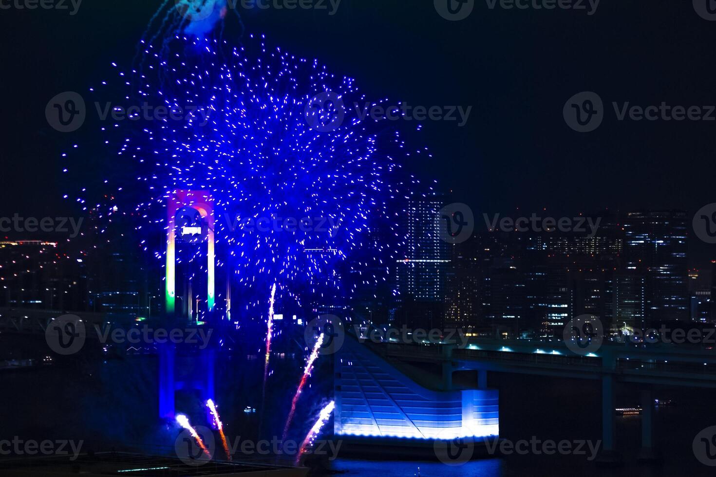 A night fireworks near Rainbow bridge at the urban city in Tokyo long shot photo