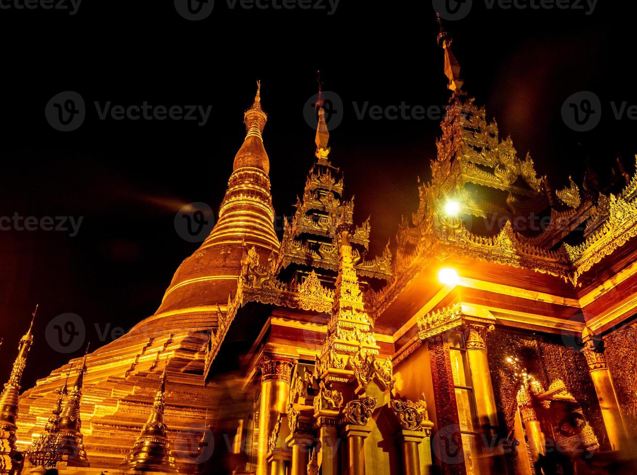 The golden pagodas and mondops are illuminated in the light of the night photo