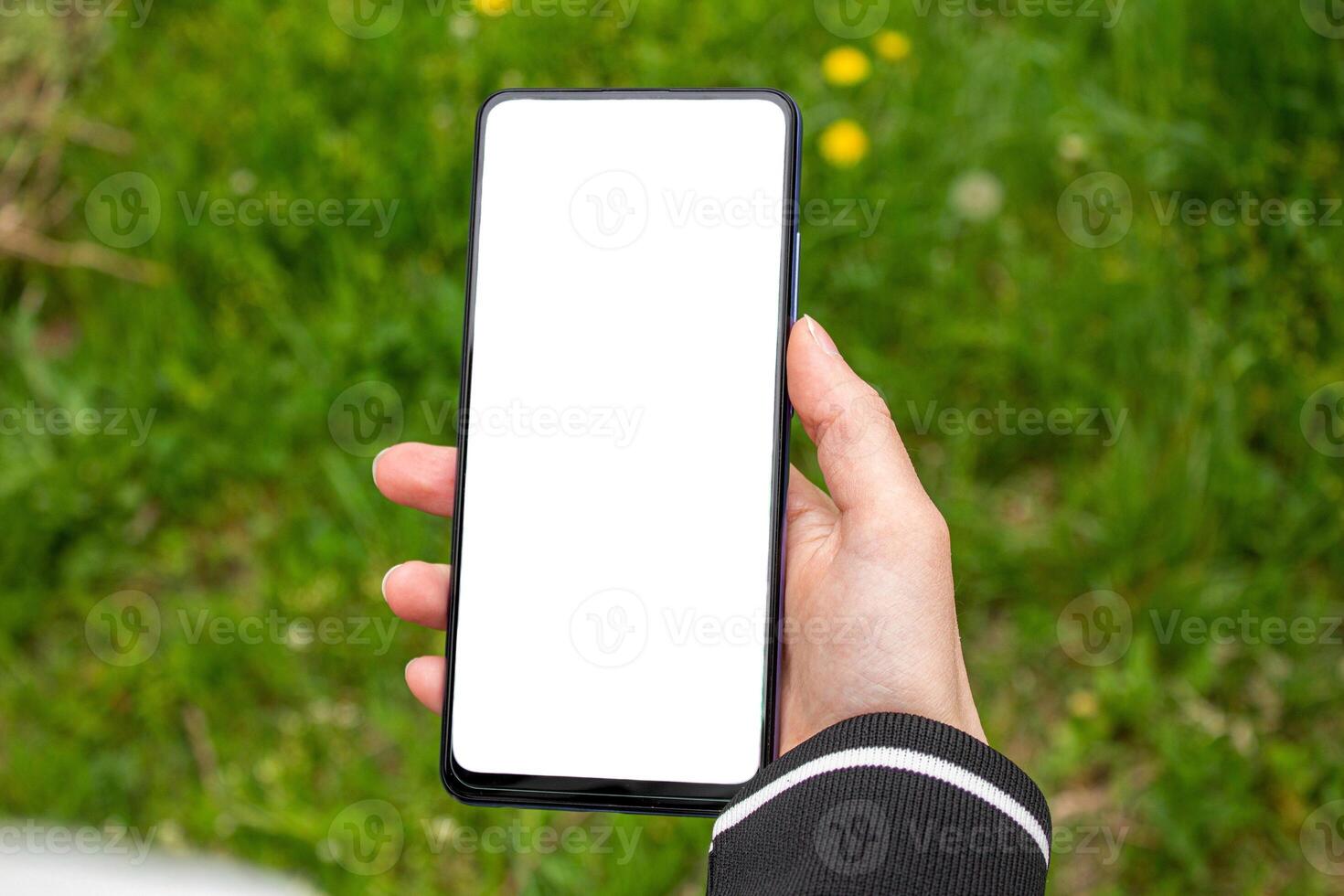 Hand holding a smartphone with blank white screen. Mockup phone. photo