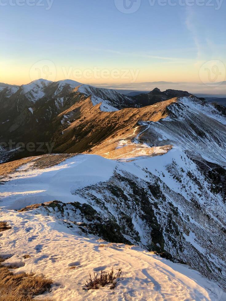 Golden Sunset Over Snow-Capped Mountain Ridges. The Tranquil Beauty Of A Remote Landscape. Adventure, Nature, And Serenity. The Tatry Mountains, Zakopane, Poland, 13 December 2024 photo