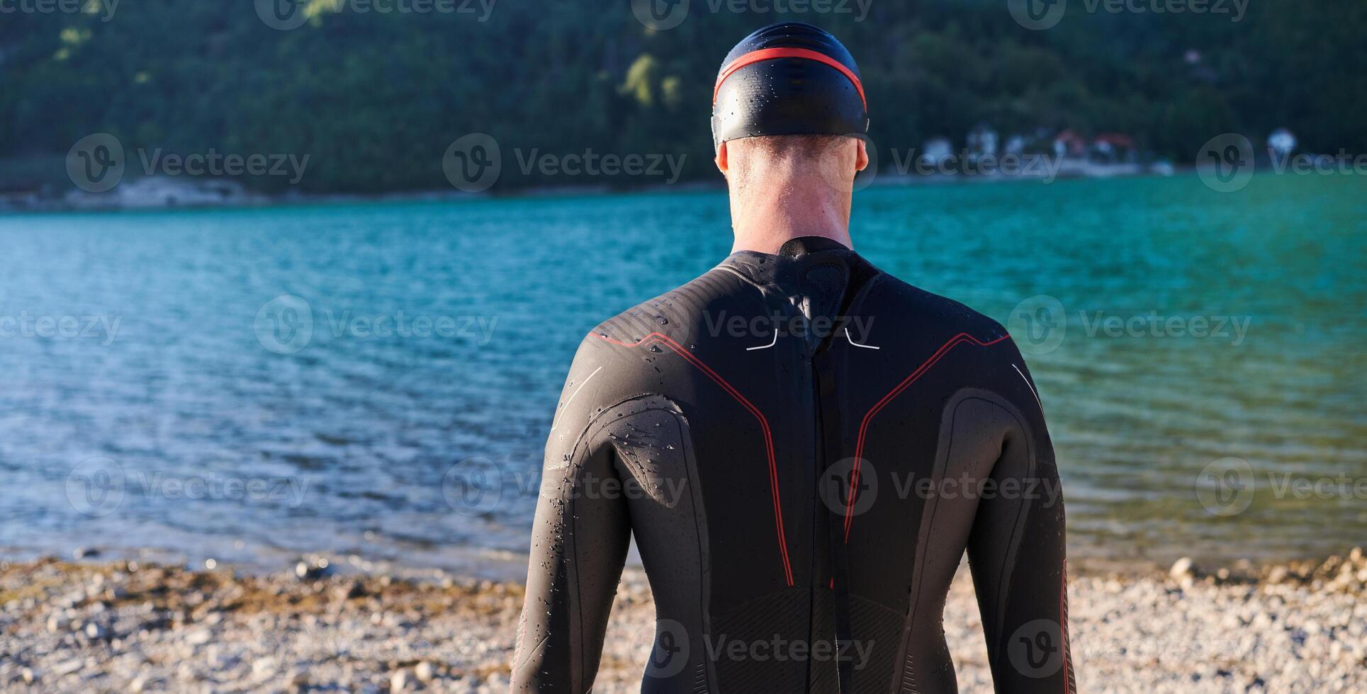 Authentic triathlon athlete getting ready for swimming training on lake photo