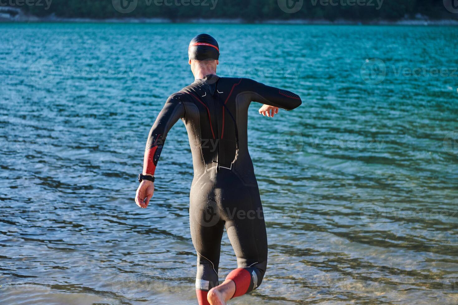 Triathlon athlete starting swimming training on lake photo