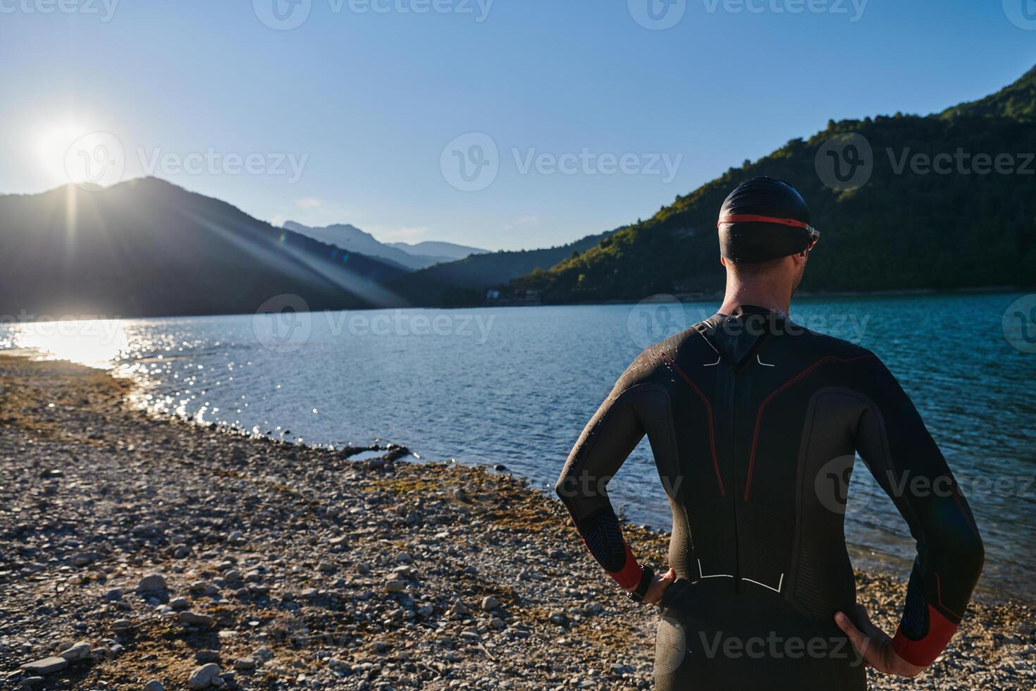 Authentic triathlon athlete getting ready for swimming training on lake photo
