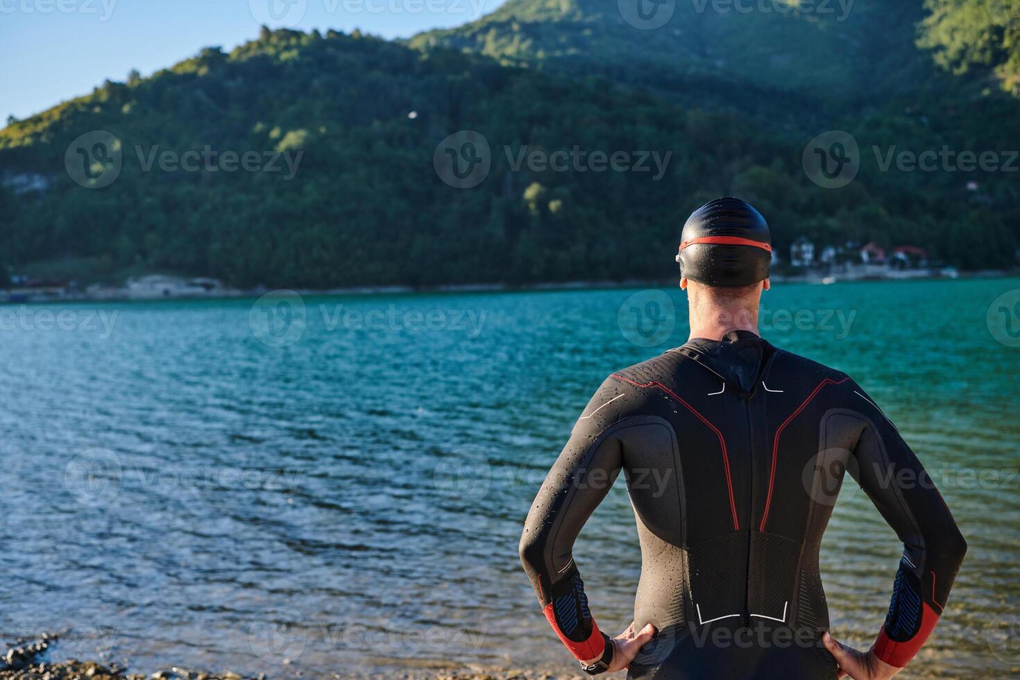 Authentic triathlon athlete getting ready for swimming training on lake photo