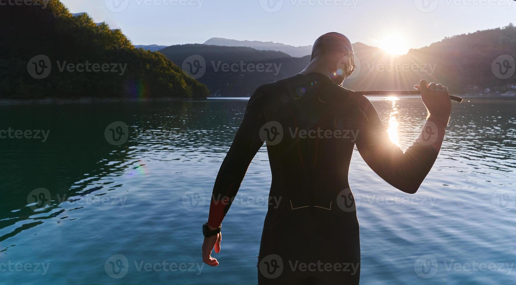 Authentic triathlon athlete getting ready for swimming training on lake photo