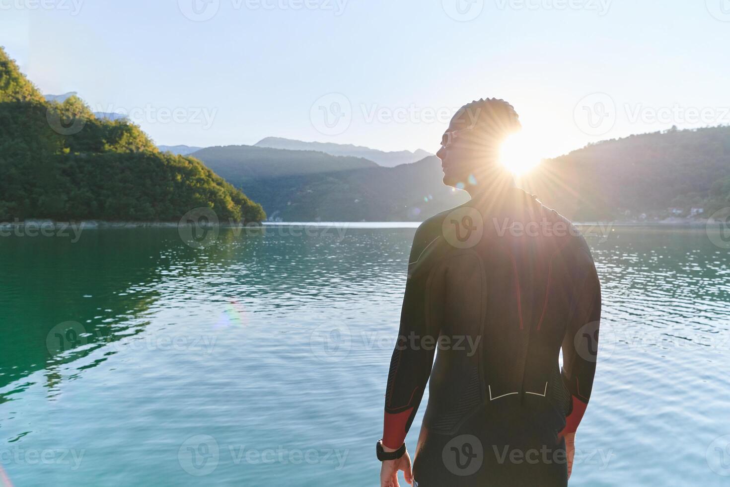 Authentic triathlon athlete getting ready for swimming training on lake photo