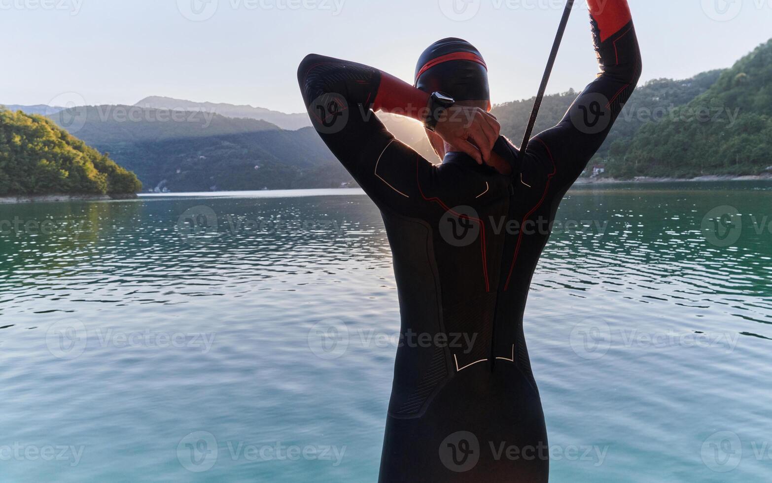 Authentic triathlon athlete getting ready for swimming training on lake photo