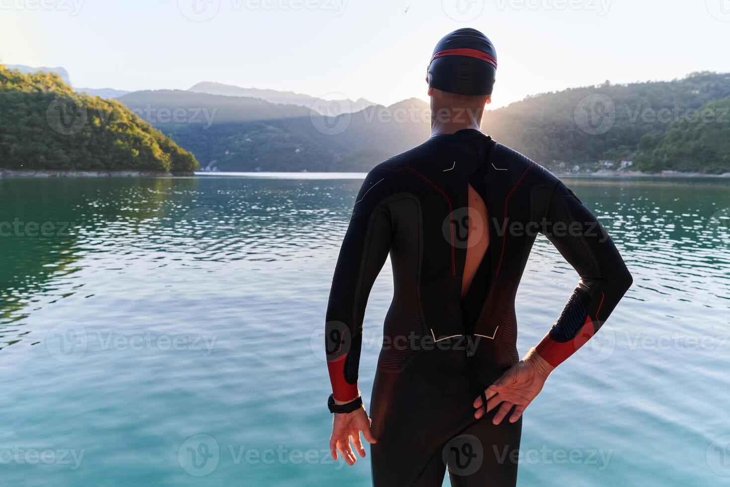 Authentic triathlon athlete getting ready for swimming training on lake photo