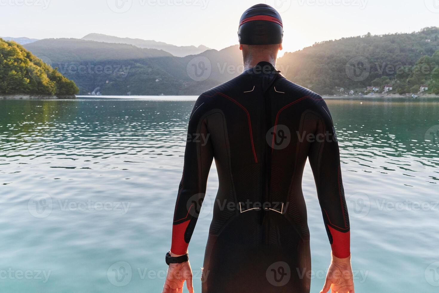 Authentic triathlon athlete getting ready for swimming training on lake photo