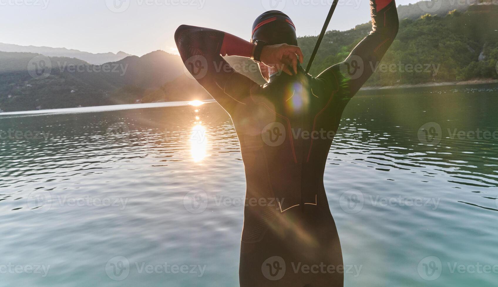Authentic triathlon athlete getting ready for swimming training on lake photo