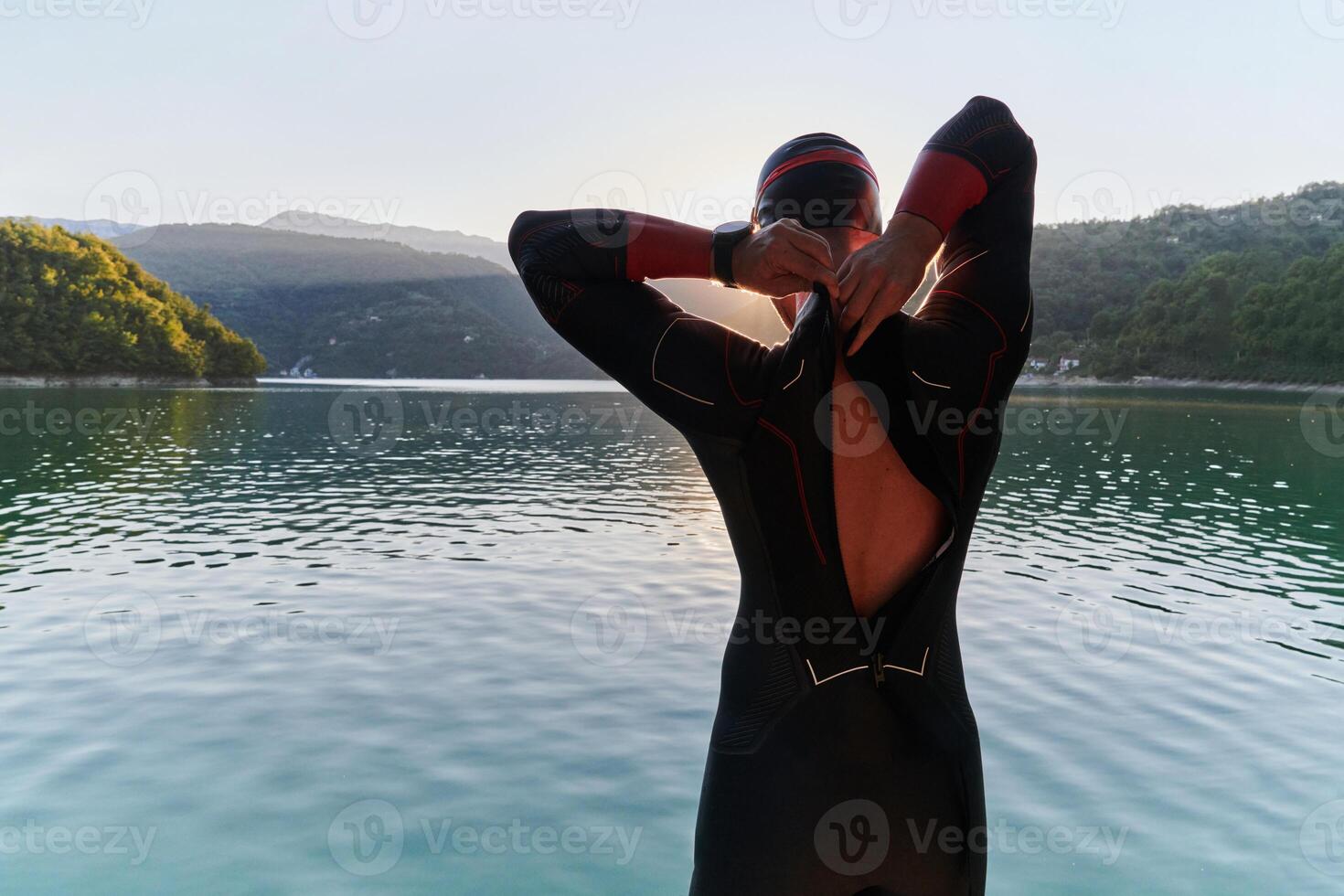 Authentic triathlon athlete getting ready for swimming training on lake photo