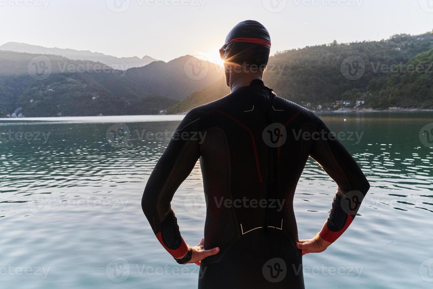 Authentic triathlon athlete getting ready for swimming training on lake photo
