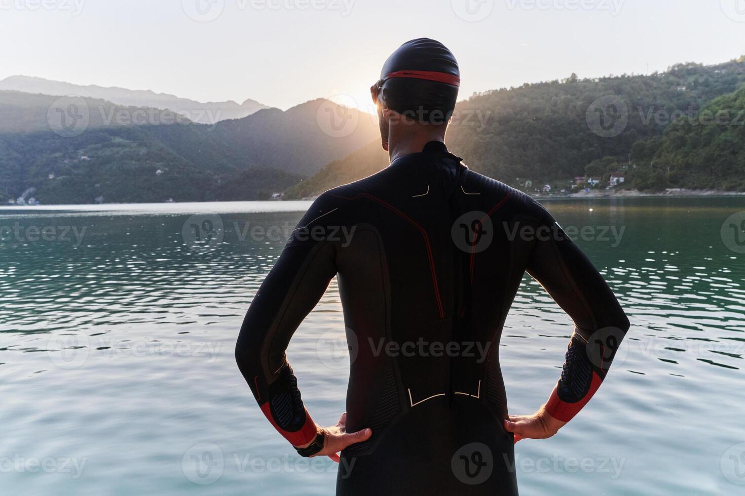 Authentic triathlon athlete getting ready for swimming training on lake photo