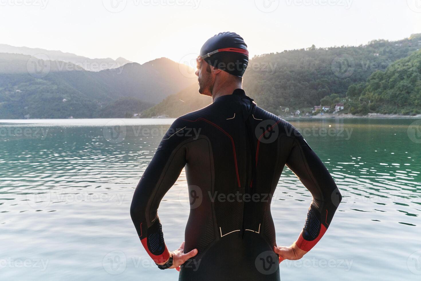 Authentic triathlon athlete getting ready for swimming training on lake photo
