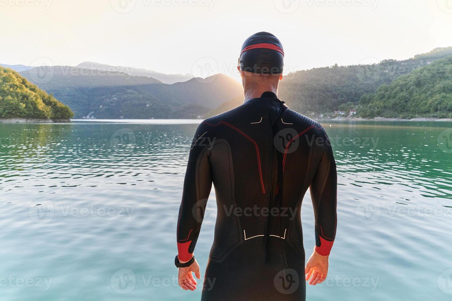 Authentic triathlon athlete getting ready for swimming training on lake photo