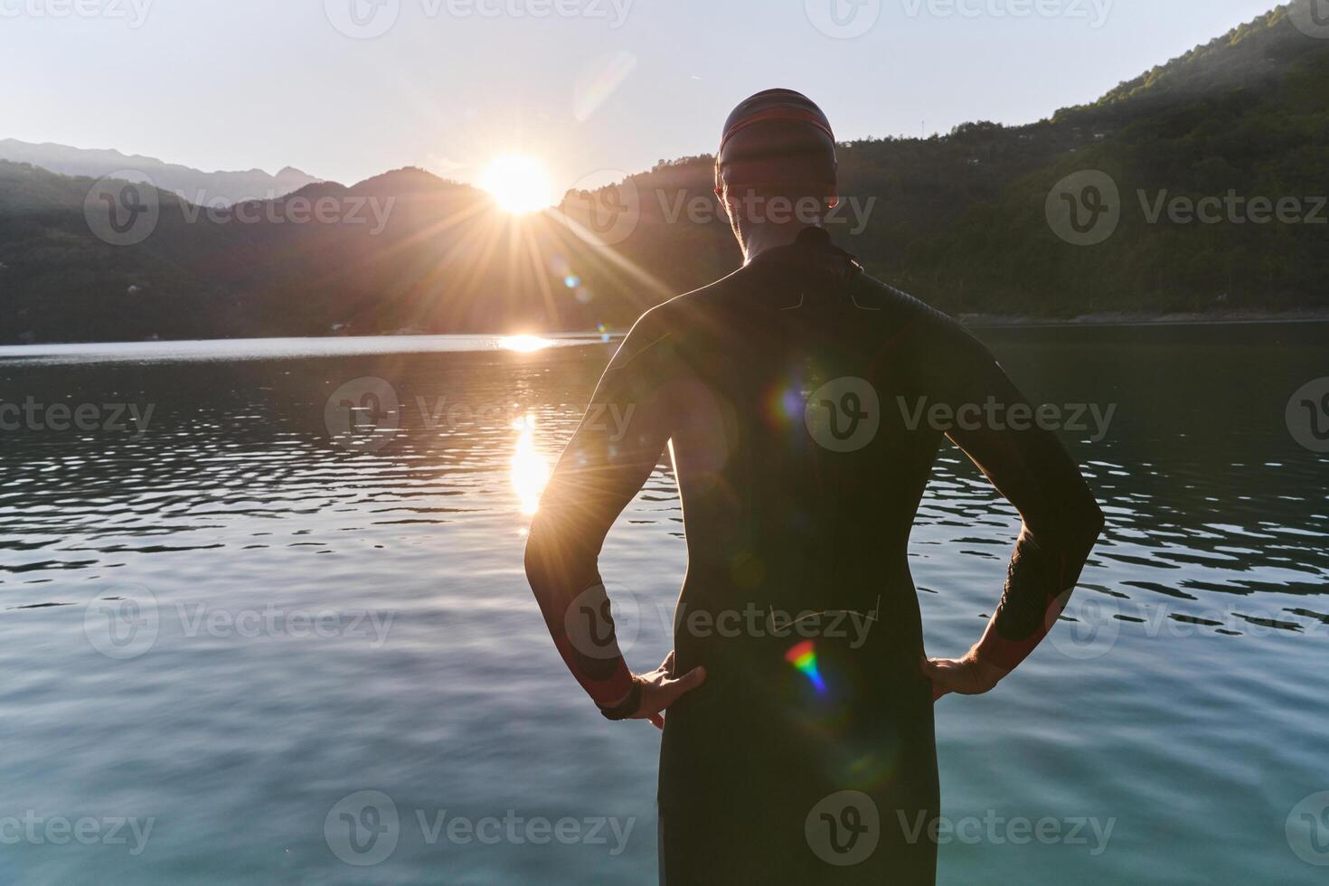 Authentic triathlon athlete getting ready for swimming training on lake photo
