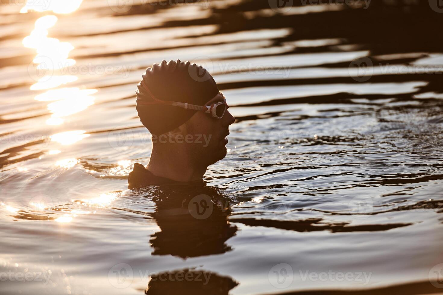 A triathlete finds serene rejuvenation in a lake, basking in the tranquility of the water after an intense training session photo