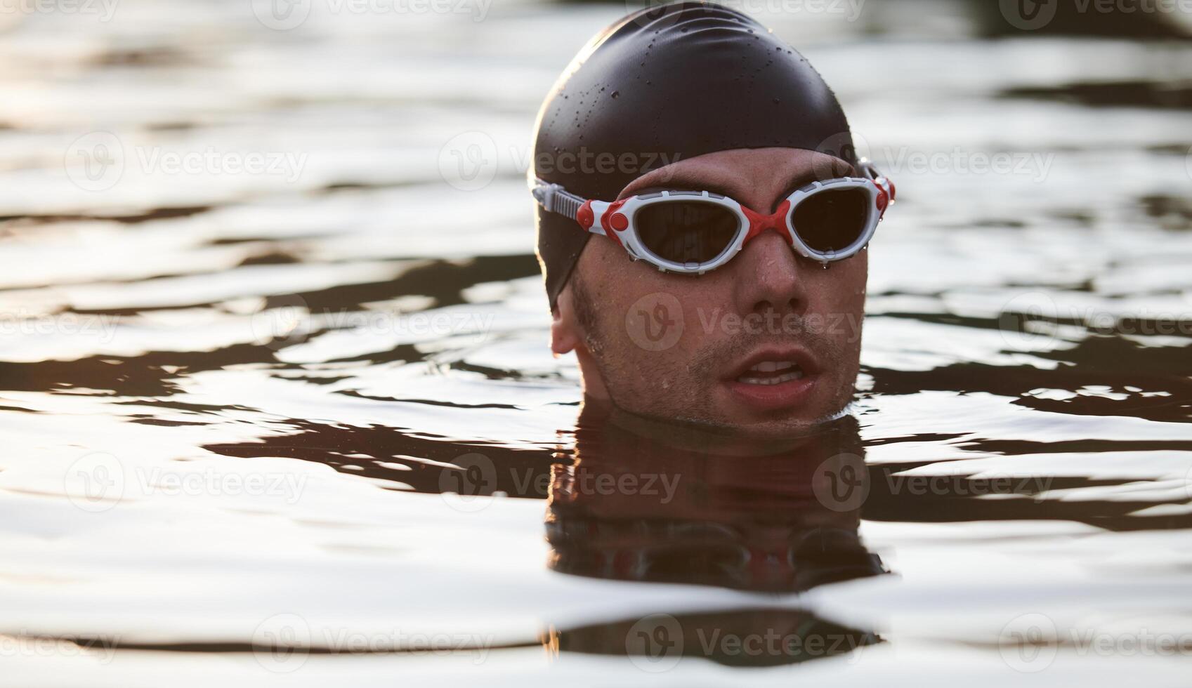 A triathlete finds serene rejuvenation in a lake, basking in the tranquility of the water after an intense training session photo