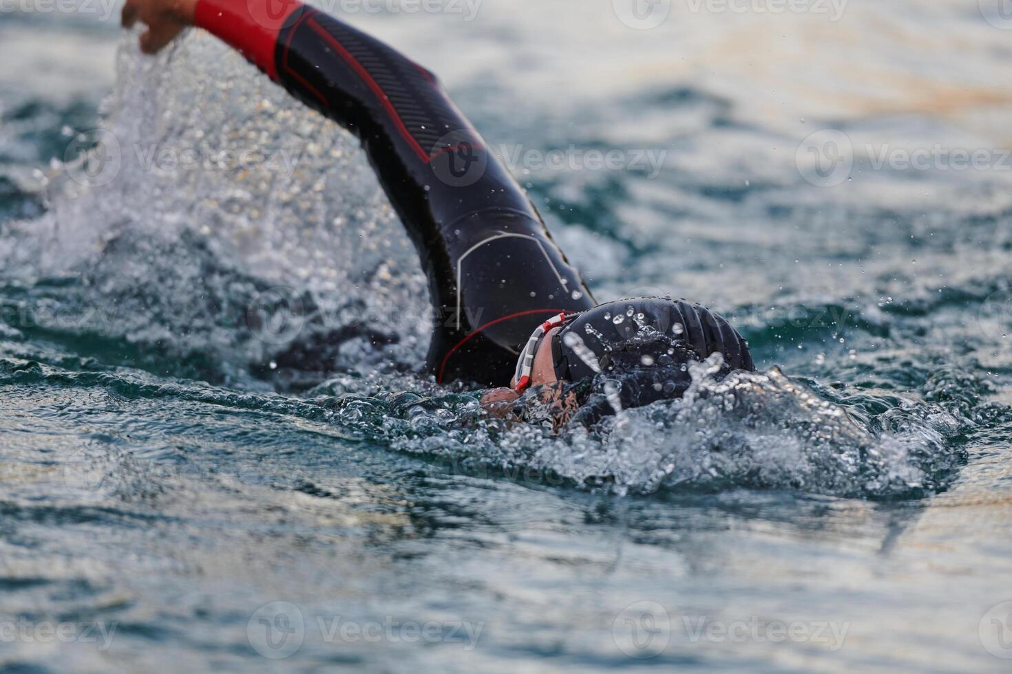 A professional triathlete trains with unwavering dedication for an upcoming competition at a lake, emanating a sense of athleticism and profound commitment to excellence. photo