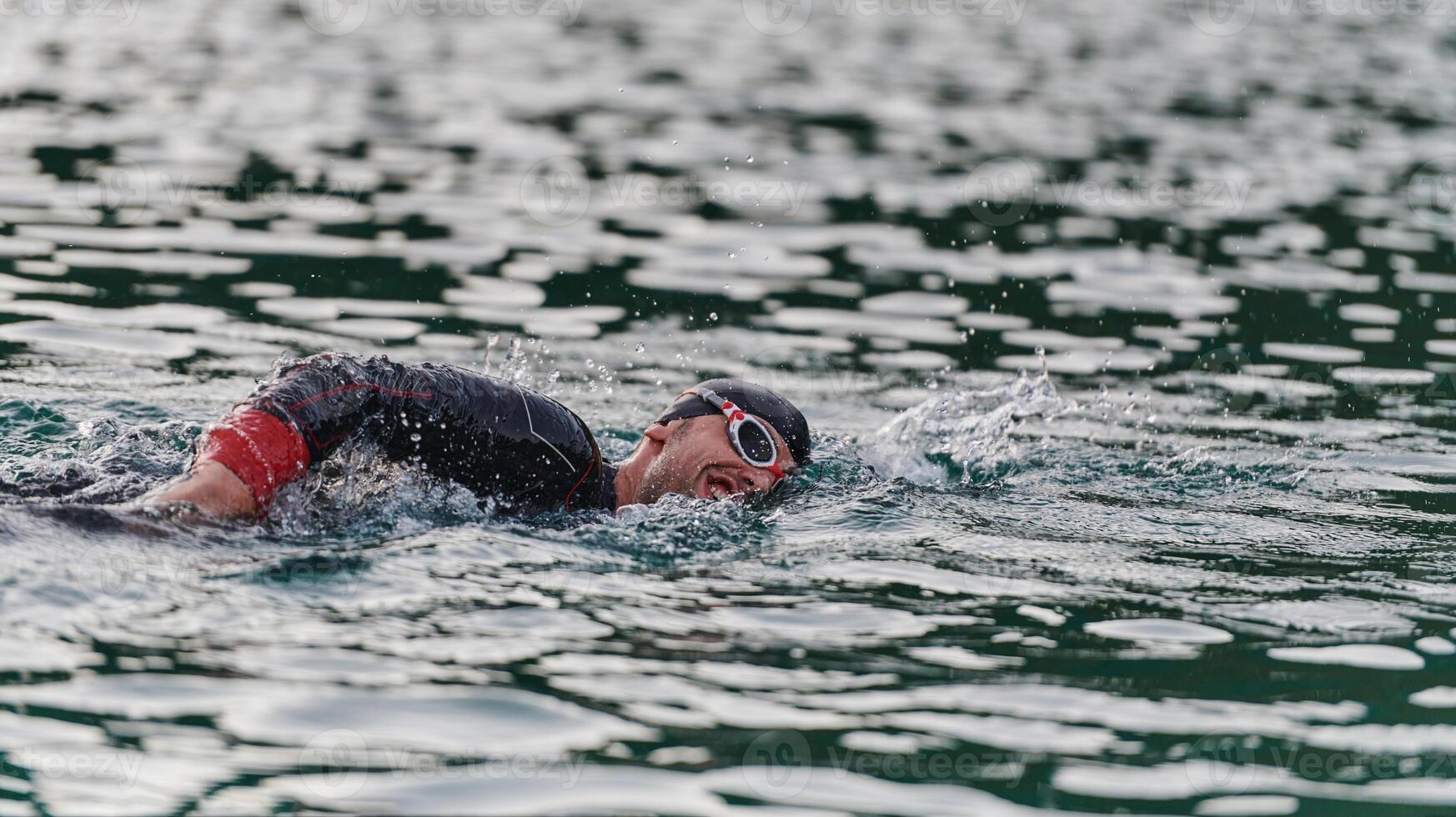 A professional triathlete trains with unwavering dedication for an upcoming competition at a lake, emanating a sense of athleticism and profound commitment to excellence. photo