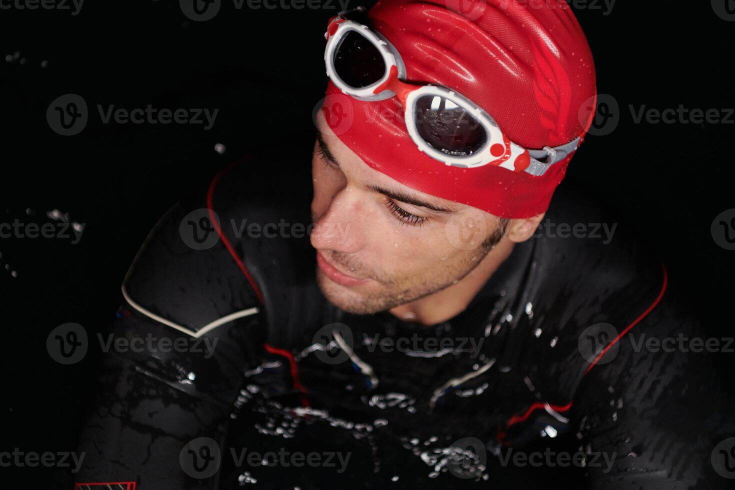 Authentic triathlete swimmer having a break during hard training on night photo