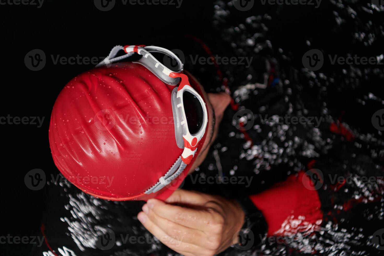 A determined professional triathlete undergoes rigorous night time training in cold waters, showcasing dedication and resilience in preparation for an upcoming triathlon swim competition photo