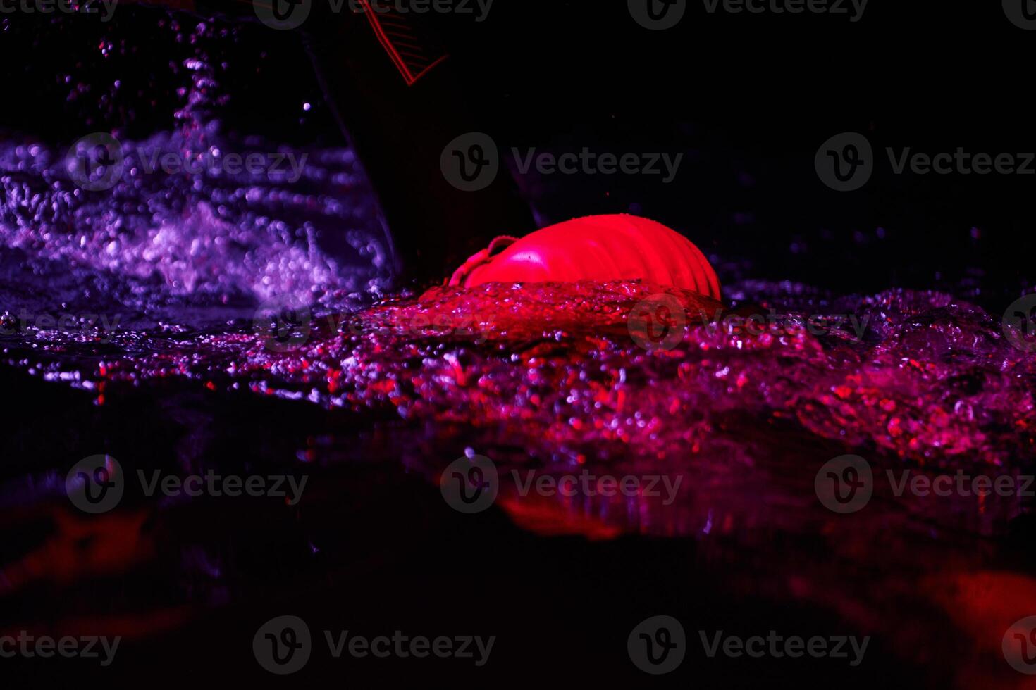 Authentic triathlete swimmer having a break during hard training on night neon gel light photo