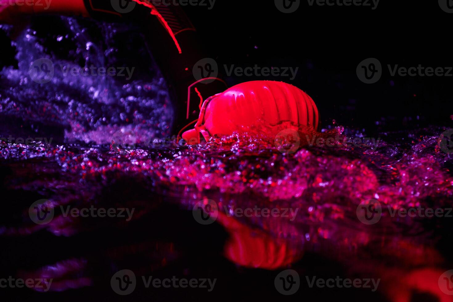 Authentic triathlete swimmer having a break during hard training on night neon gel light photo