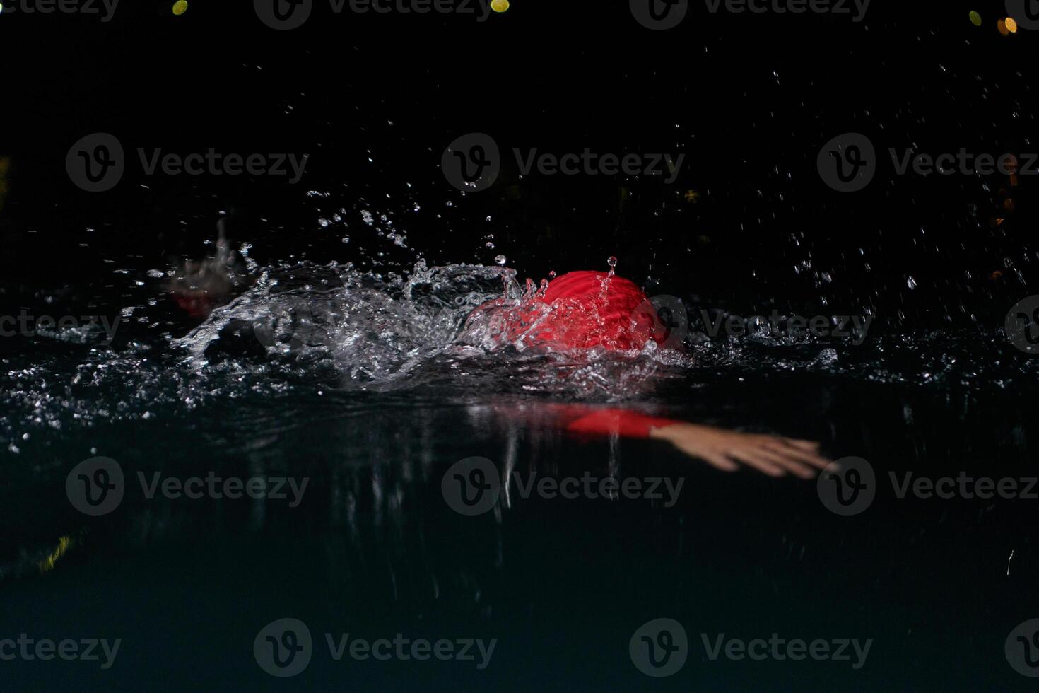 A determined professional triathlete undergoes rigorous night time training in cold waters, showcasing dedication and resilience in preparation for an upcoming triathlon swim competition photo