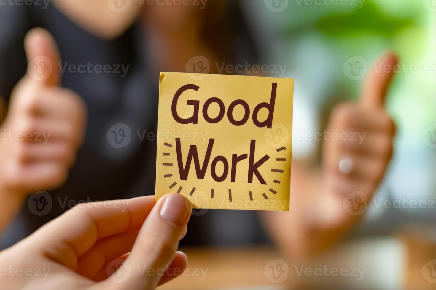 A person holding up a sticky note with the word good work photo
