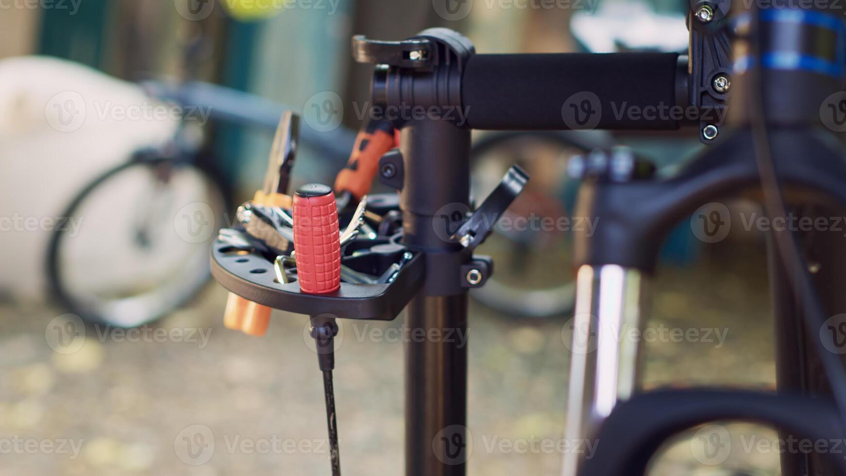 Zoom-in shot offering clear view of professional equipment displayed on repair-stand signifying readiness for bicycle maintenance outdoor. Various specialized work tools placed on bike workstand. photo