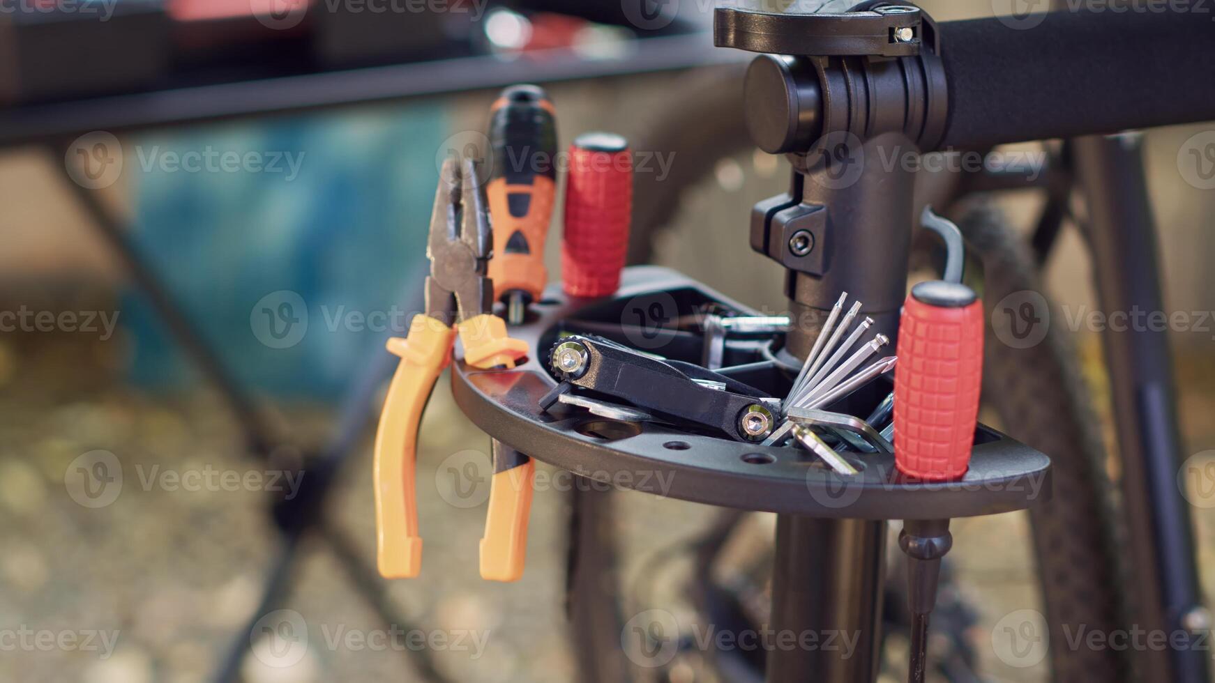 Close-up shot of variety of expert tools arranged on a repair-stand and ready for bike maintenance. Zoomed-in view of various repair and restoration professional tools for bicycles in yard. photo