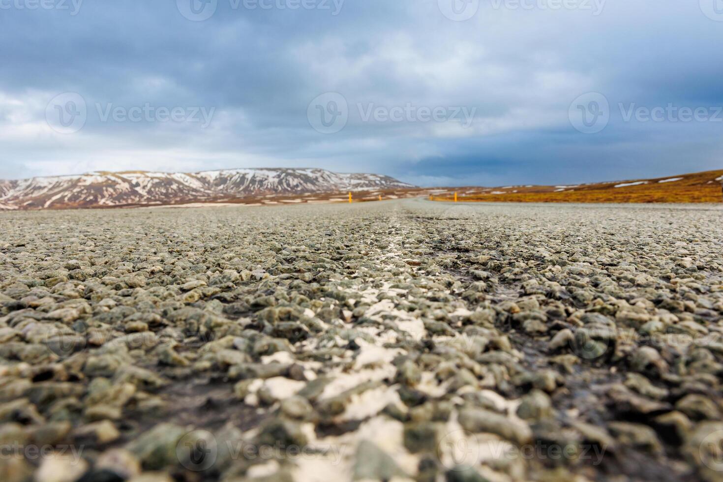 Icelandic landscape and long road in scandinavian scenery with empty roadside, frozen lands and fields in iceland. Spectacular panoramic view of arctic countryside, snowy mountains tops. photo