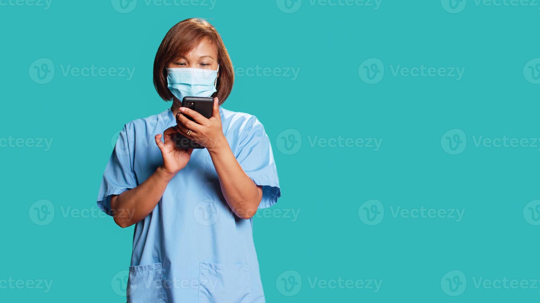 Worried nurse delivering bad news to patient in telemedicine phone chat. Clinic employee overthinking upsetting message for hospital visitor, isolated over blue studio background photo