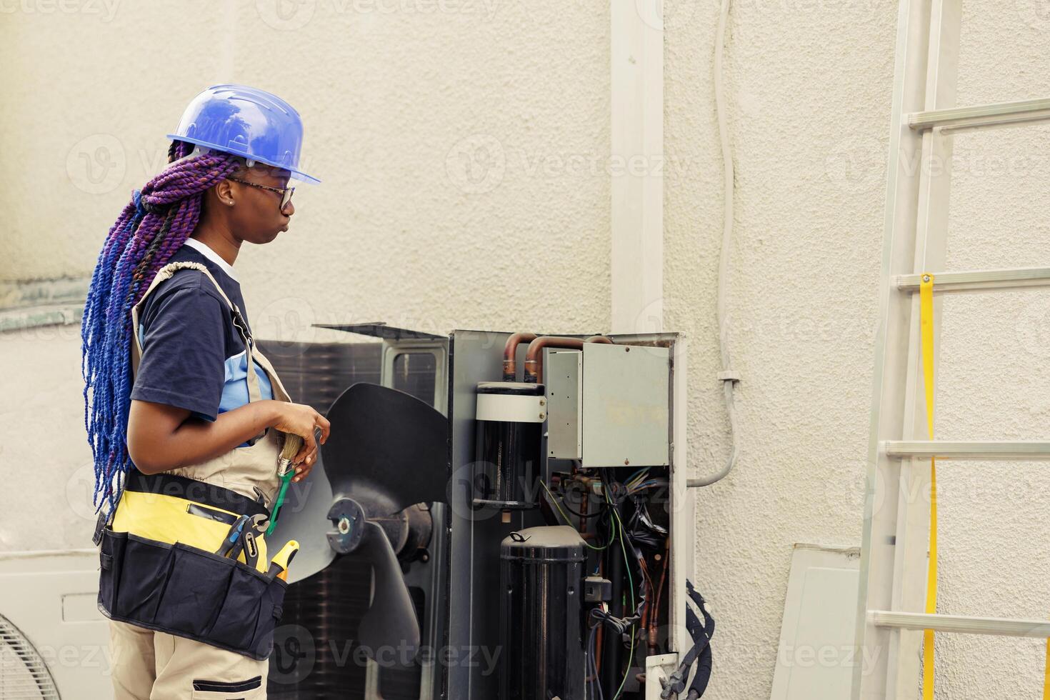 Technician ready to start work on air conditioner, commissioned to do for annual routine cleaning and maintenance removing built up layer of dirt and dust from internal parts using soft dusting brush photo