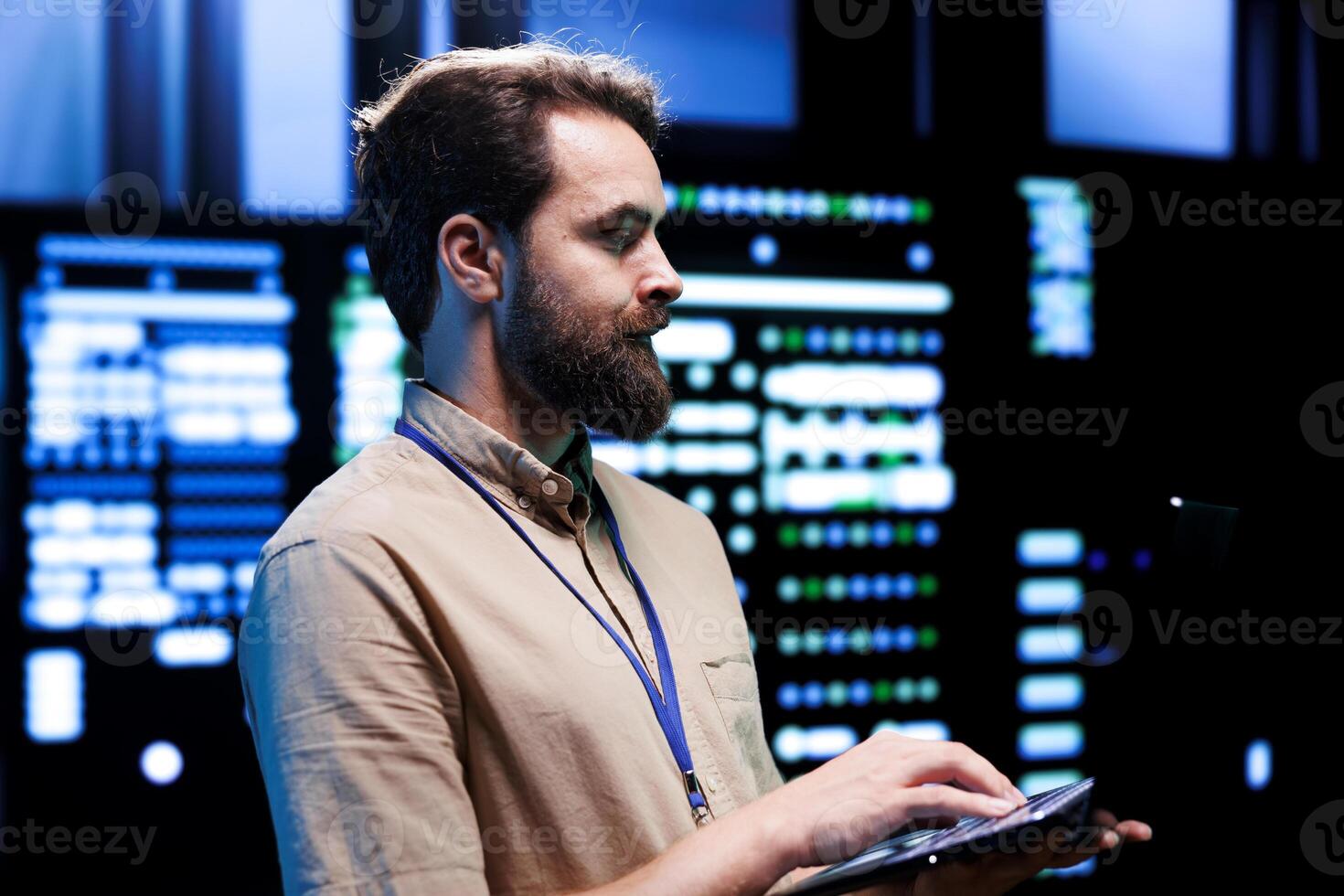 Focused serviceman checking functional blade servers in computer network security data hub. High tech facility infrastructure providing processing and memory resources for computational operations photo