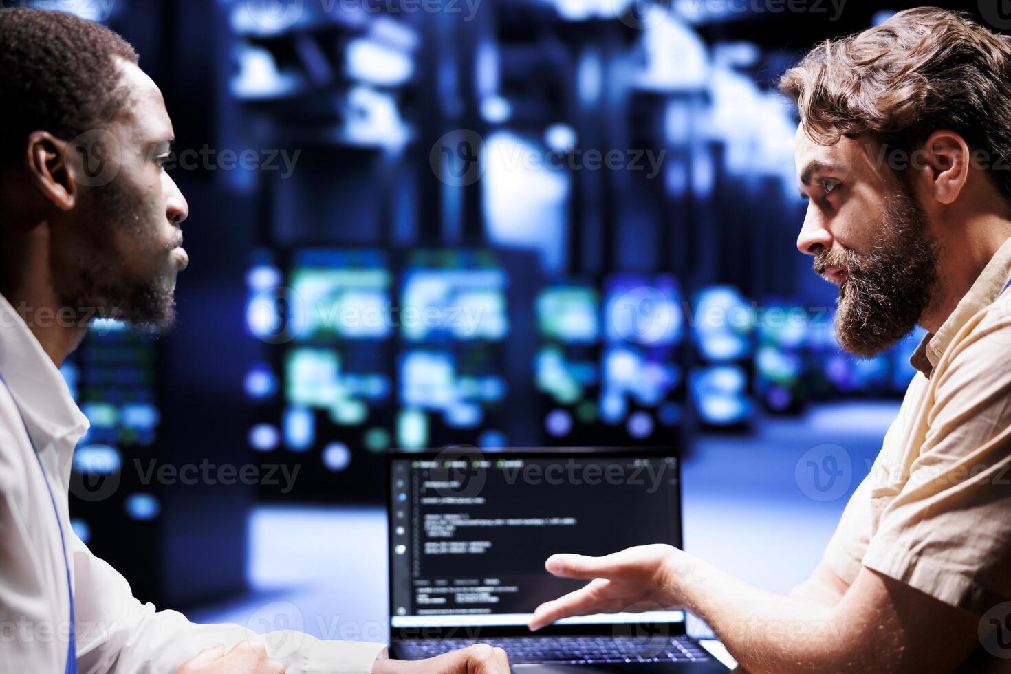 Adept IT developers colleagues writing script code in server hub on laptop terminal. Experienced programmer team doing maintenance work in cloud computing computer business updating racks software photo